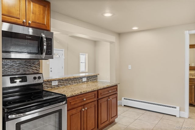 1104 Miner St, Idaho Springs, CO 80452 - kitchen with appliances with stainless steel finishes, a baseboard heating unit, light tile patterned floors, tasteful backsplash, and light stone countertops