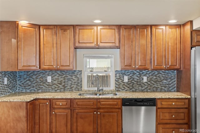 1104 Miner St, Idaho Springs, CO 80452 - kitchen with appliances with stainless steel finishes, a sink, light stone counters, brown cabinetry, and tasteful backsplash