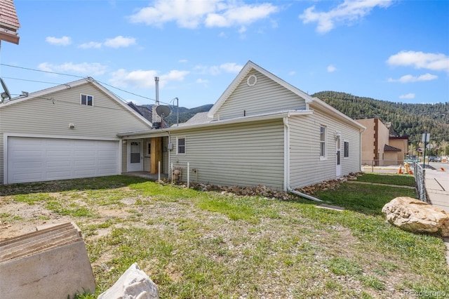 1104 Miner St, Idaho Springs, CO 80452 - rear view of house featuring an attached garage and a mountain view
