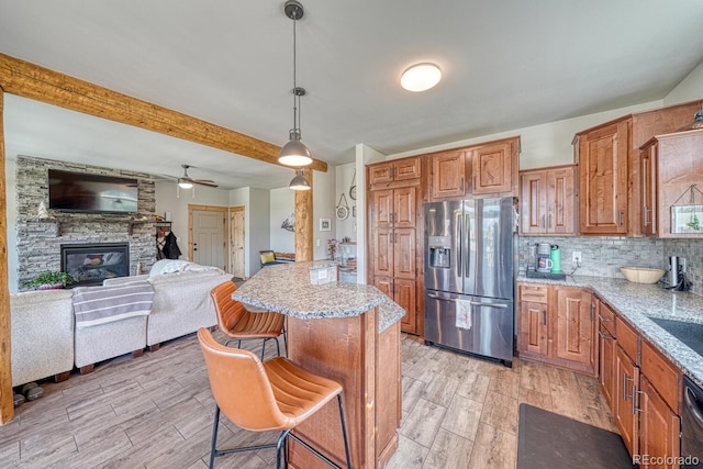 11398 County Road 302, Buena Vista, CO 81211 - kitchen with stainless steel fridge, a breakfast bar area, light wood finished floors, brown cabinets, and hanging light fixtures