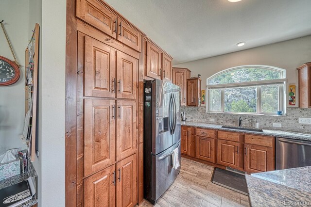 11398 County Road 302, Buena Vista, CO 81211 - kitchen with appliances with stainless steel finishes, tasteful backsplash, light stone countertops, and brown cabinets