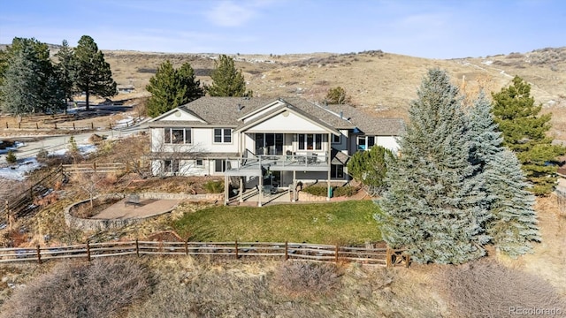 rear view of property with a yard, a rural view, a patio, and a wooden deck