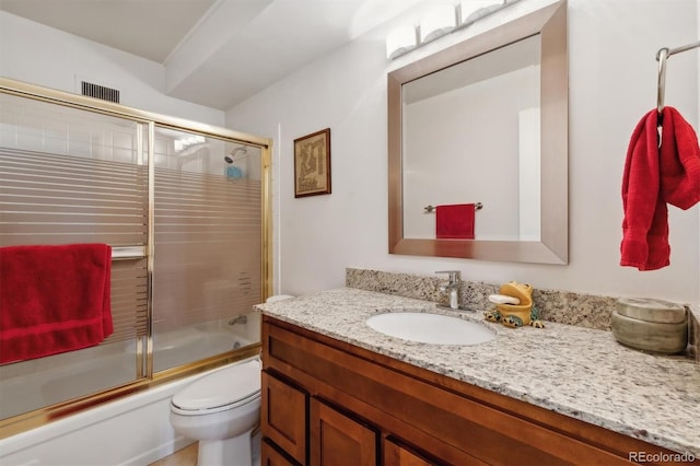 full bathroom with visible vents, vanity, shower / bath combination with glass door, and toilet