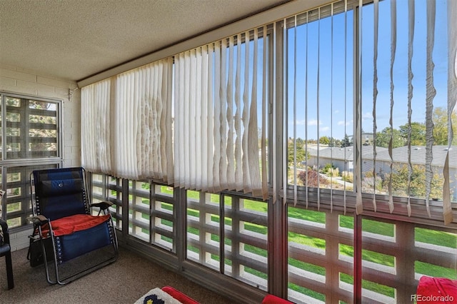 sunroom featuring carpet floors and a textured ceiling