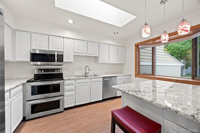 7483 W Cedar Cir, Lakewood, CO 80226 - kitchen featuring appliances with stainless steel finishes, a sink, a skylight, light wood-style flooring, and white cabinets