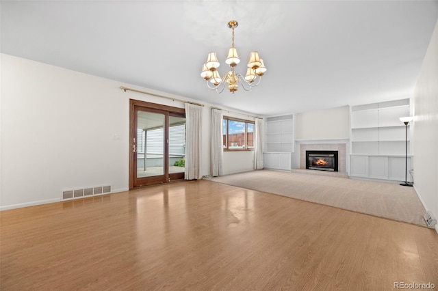 7483 W Cedar Cir, Lakewood, CO 80226 - unfurnished living room with a chandelier, wood finished floors, baseboards, and a fireplace