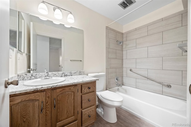 7483 W Cedar Cir, Lakewood, CO 80226 - full bath with vanity, toilet, wood finished floors, and tub / shower combination