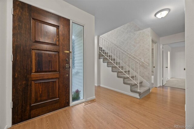 7483 W Cedar Cir, Lakewood, CO 80226 - foyer entrance featuring wood finished floors, baseboards, and stairway