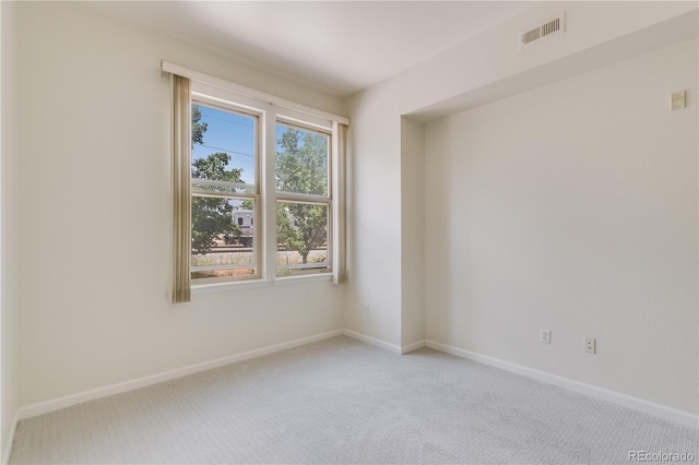 spare room with light carpet, baseboards, and visible vents