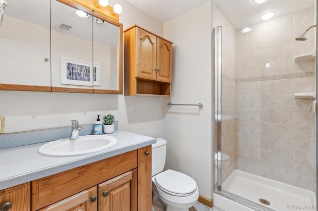 bathroom with visible vents, toilet, a stall shower, and vanity