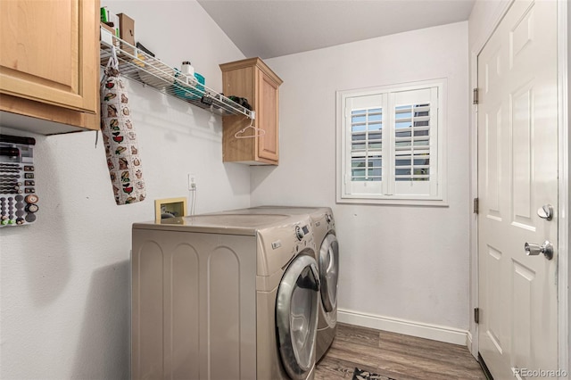 laundry area with independent washer and dryer, cabinets, and dark hardwood / wood-style flooring