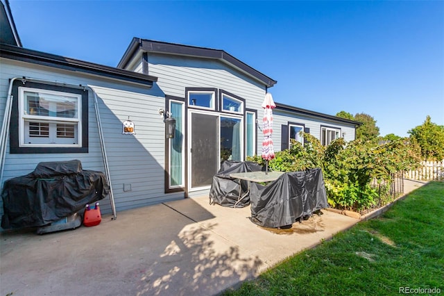 back of property with a patio and a lawn