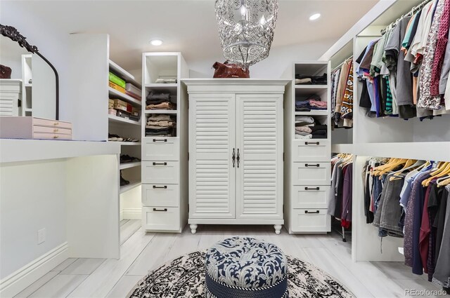 walk in closet featuring an inviting chandelier