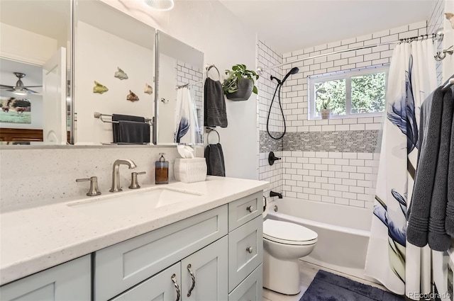 full bathroom featuring vanity, shower / bath combination with curtain, a ceiling fan, and toilet
