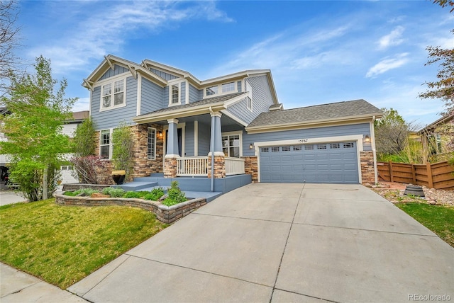 view of front of property with a porch, board and batten siding, driveway, an attached garage, and stone siding