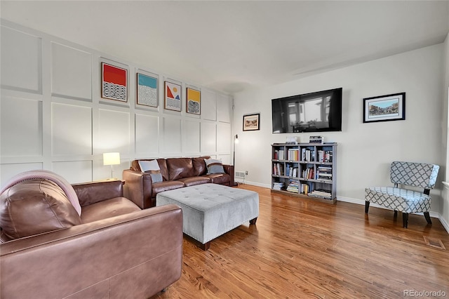 living area featuring baseboards and wood finished floors