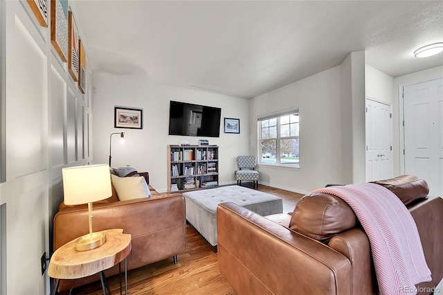 living area with light wood-style floors and baseboards