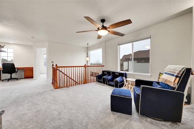 living area with ceiling fan and light colored carpet