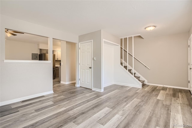 3401 W Milan Ave, Denver, CO 80236 - unfurnished living room with stairway, light wood finished floors, ceiling fan, and baseboards