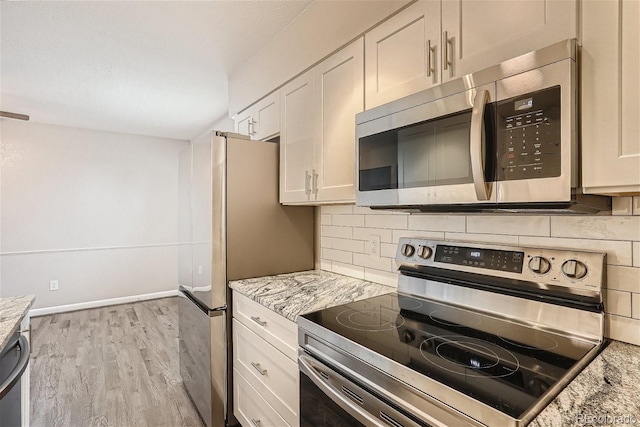 3401 W Milan Ave, Denver, CO 80236 - kitchen with appliances with stainless steel finishes, decorative backsplash, light wood finished floors, and light stone countertops
