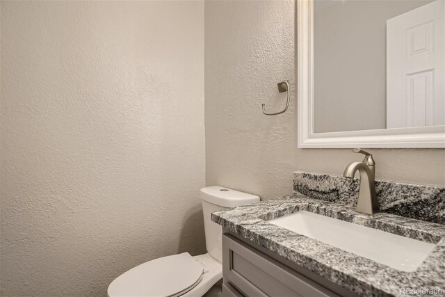 3401 W Milan Ave, Denver, CO 80236 - bathroom with a textured wall, toilet, and vanity