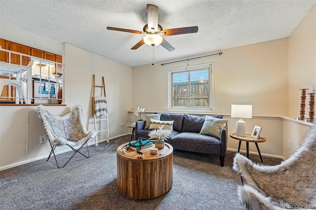 living room with baseboards, carpet, a ceiling fan, and a textured ceiling