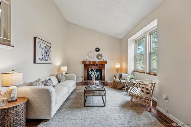 living area featuring baseboards, vaulted ceiling, wood finished floors, and visible vents