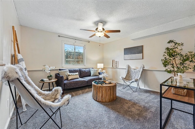 living area featuring a textured ceiling, ceiling fan, and carpet