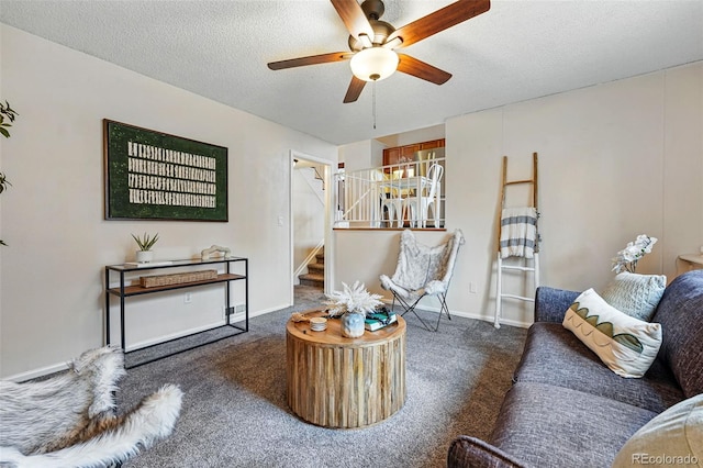 living area with stairway, ceiling fan, carpet, and a textured ceiling