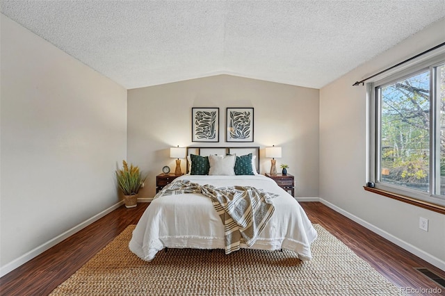 bedroom featuring baseboards, vaulted ceiling, wood finished floors, and visible vents