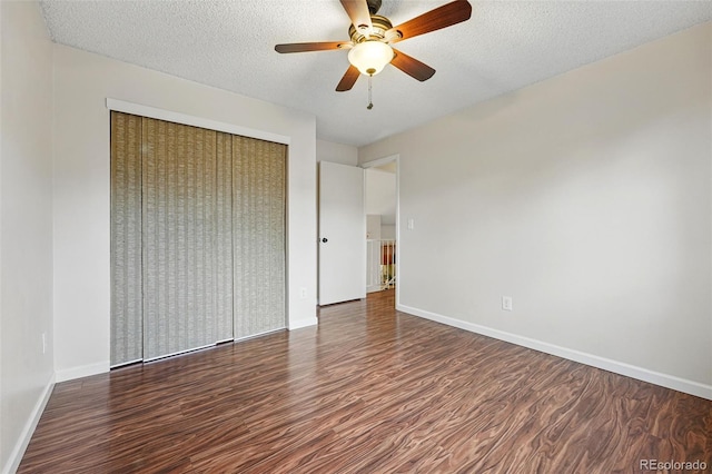 unfurnished bedroom featuring baseboards, wood finished floors, and a closet