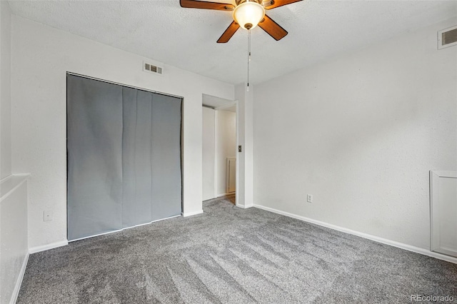 unfurnished bedroom featuring a textured ceiling, visible vents, baseboards, a closet, and carpet flooring
