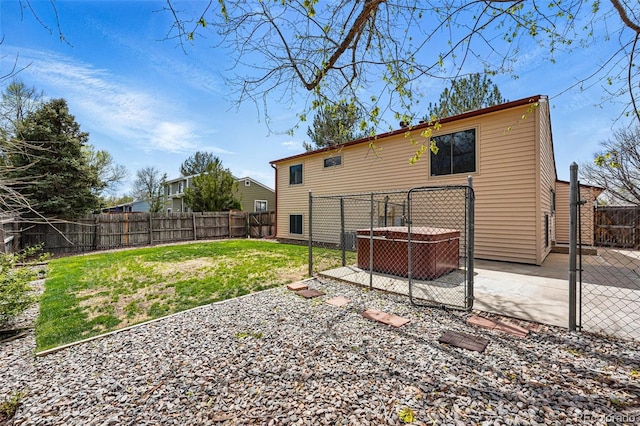 rear view of property featuring a fenced backyard, a lawn, and a patio area
