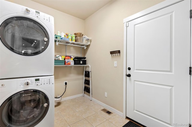 clothes washing area with stacked washer and dryer and light tile patterned floors