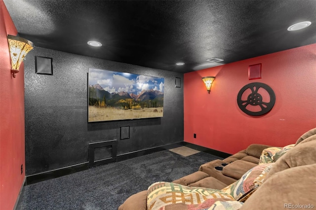 carpeted home theater room featuring a textured ceiling