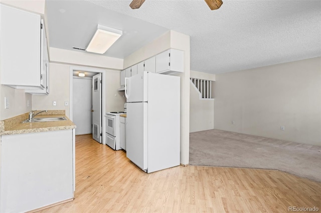 2638 Hearthwood Ln, Colorado Springs, CO 80917 - kitchen featuring white appliances, a ceiling fan, white cabinetry, light wood-style flooring, and a textured ceiling