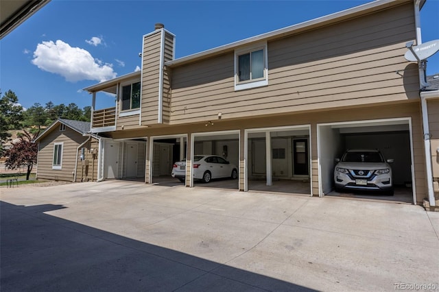 2638 Hearthwood Ln, Colorado Springs, CO 80917 - back of house with a chimney, driveway, and a carport