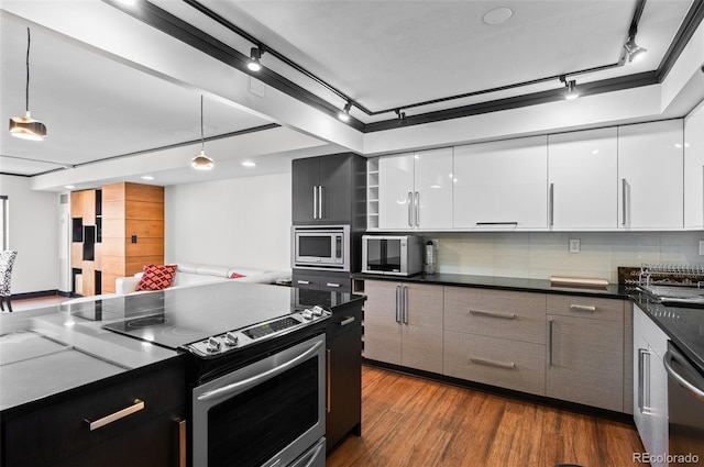 kitchen with pendant lighting, stainless steel appliances, backsplash, and white cabinets