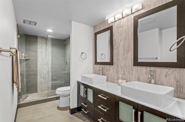 bathroom featuring vanity, an enclosed shower, and toilet