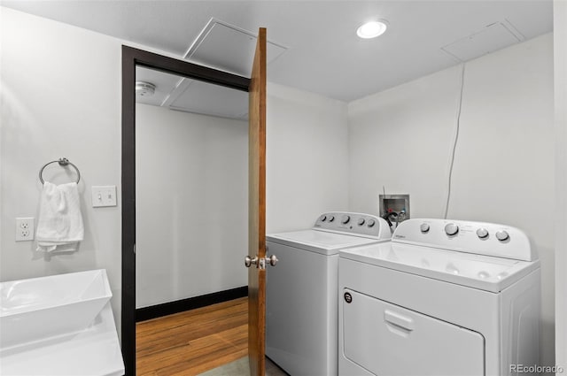 washroom with sink, independent washer and dryer, and light hardwood / wood-style floors