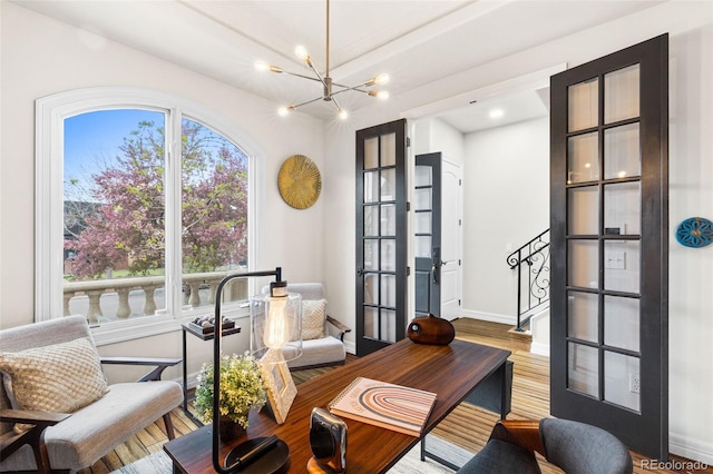 home office featuring an inviting chandelier, baseboards, and wood finished floors