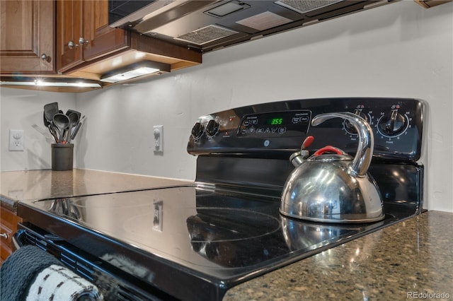 801 Trailhead Cir Unit 812, Winter Park, CO 80482 - kitchen view of black electric range oven, brown cabinetry, and dark stone counters