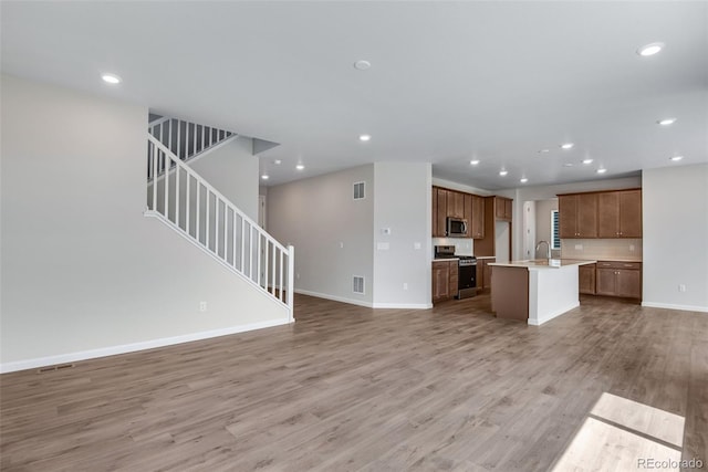 unfurnished living room featuring light hardwood / wood-style floors and sink