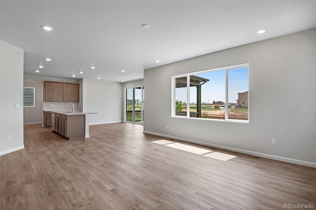 unfurnished living room with sink and light wood-type flooring