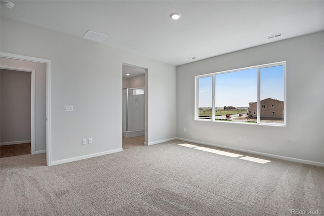 unfurnished bedroom with light colored carpet and a walk in closet