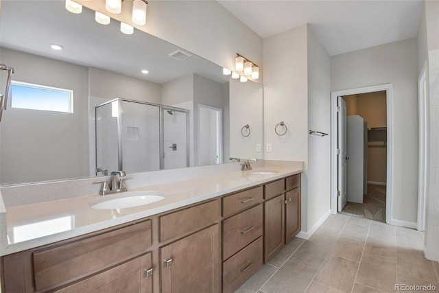 bathroom featuring a shower with shower door, tile patterned flooring, and double sink vanity