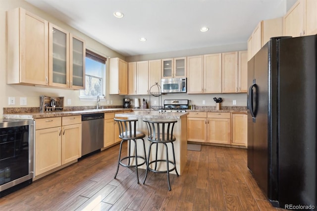 kitchen featuring wine cooler, a kitchen breakfast bar, dark hardwood / wood-style flooring, stainless steel appliances, and light brown cabinets