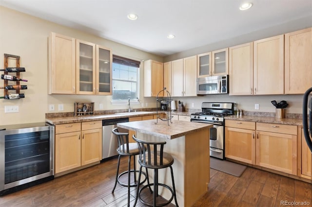 kitchen featuring wine cooler, stainless steel appliances, a kitchen island, and light brown cabinets