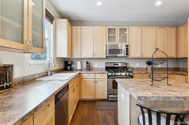 kitchen featuring stainless steel appliances, sink, light brown cabinetry, and dark hardwood / wood-style floors