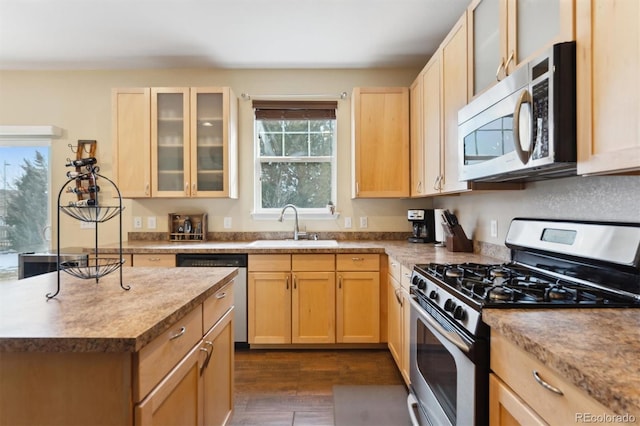 kitchen featuring stainless steel appliances, light brown cabinetry, and sink